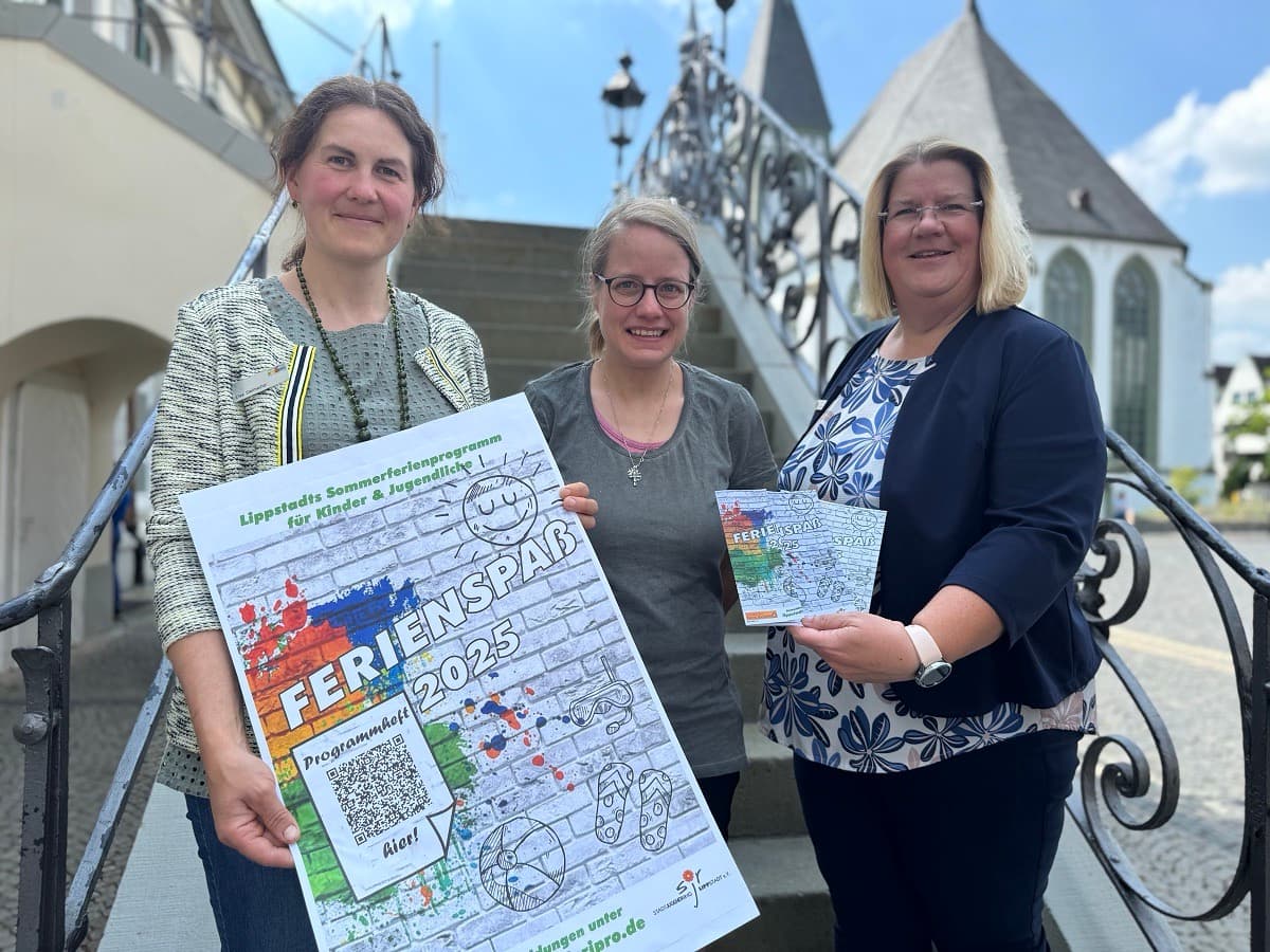 3 Frauen halten Plakate und Broschüren zum Ferienspaß 2025 hoch