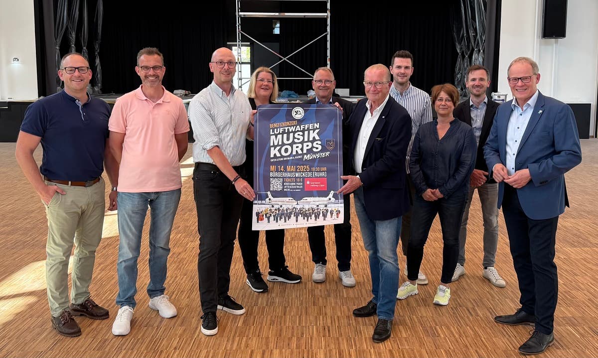 Plakat zum Benefizkonert wird von einigen Menschen Präsentiert